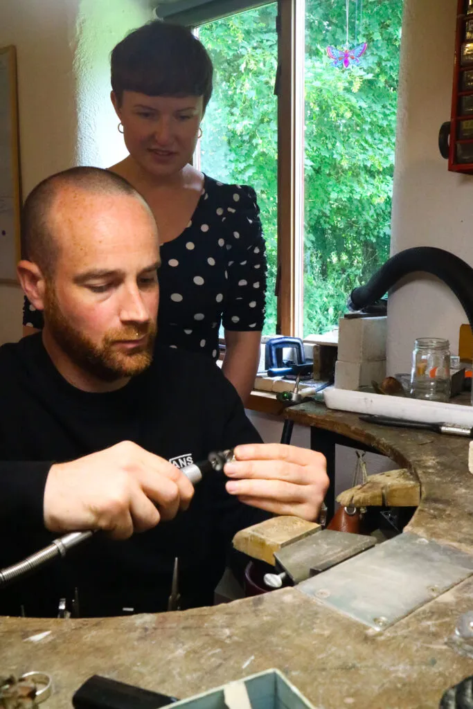 Wife looks on as husband makes her ring at Tiffany Budds workshop